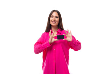 happy positive young brunette lady dressed in bright pink shirt holding plastic credit card