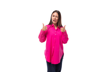 Obraz na płótnie Canvas positive inspired young brunette lady dressed in a bright pink shirt and jeans on a white background