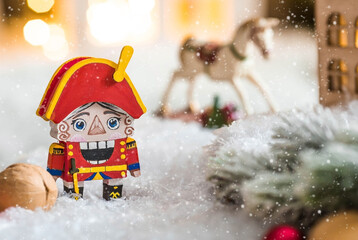 A toy soldier Nutcracker and walnuts on a Christmas background with a garland. Tchaikovsky's...