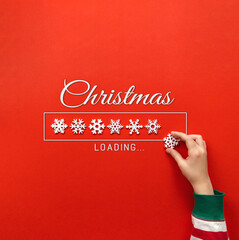 loading christmas. hand puts snowflake on red background. holiday banner