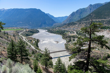 Obraz na płótnie Canvas High level panoramic view from Lillooet viewpoint over Fraser River, BC, Canada with below the Lillooet Suspension Bridge or Lillooet Old Bridge connecting Lillooet with British Columbia Highway 99