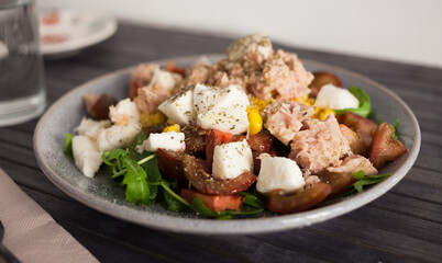 Plate of salad with tuna, corn, tomatoes and arugula