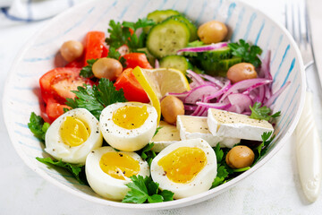 Breakfast. Greek salad and boiled eggs. Fresh vegetable salad with tomato, cucumbers, olives, arugula and cheese.