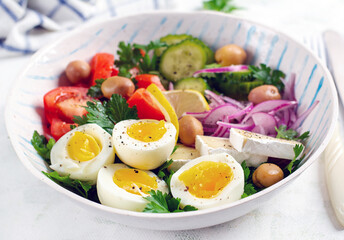 Breakfast. Greek salad and boiled eggs. Fresh vegetable salad with tomato, cucumbers, olives, arugula and cheese.