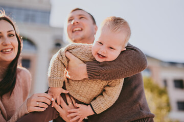 Fototapeta premium Parents play with their child close-up. Boy flying and laughing, happy family having fun together