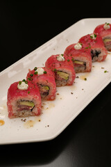 Sushi rolls with tuna fish and sauce, close-up.