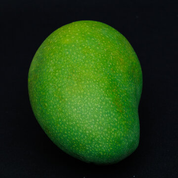 Single whole mango harumanis isolated on black