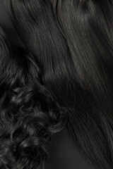 Natural looking shiny hair, bunch of dark brunette colors curls and wigs isolated on black...