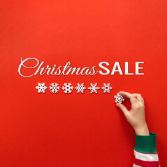 christmas sale banner. red background with snowflakes, hand and text