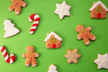 Tasty gingerbread cookies on green background