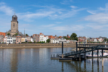 Obraz premium Panoramic view over the IJssel river towards the medieval city of Deventer, the Netherlands with in the middle the mains church of the city, the Great Church or St. Lebuinus Church