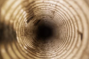 Fotobehang inside view of dirty corrugated drainage pipe © ronstik
