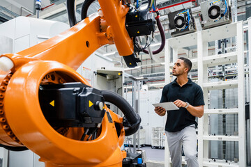 Technician examining industrial robot in a factory