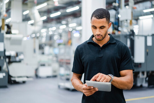 Technician using digital tablet on shop floor in a factory
