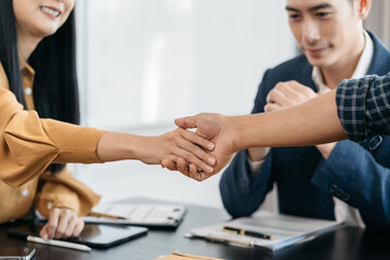 Lawyer shaking hands with client after discussing final contract agreement.