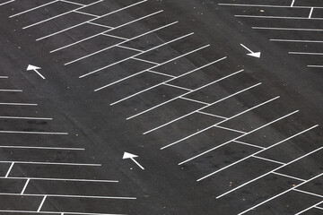 Empty parking space. Aerial photo with an asphalt parking lot in front of a shopping center and office buildings. Transportation industry. © Dragoș Asaftei
