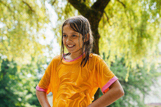 Smiling girl wearing wet clothes at park