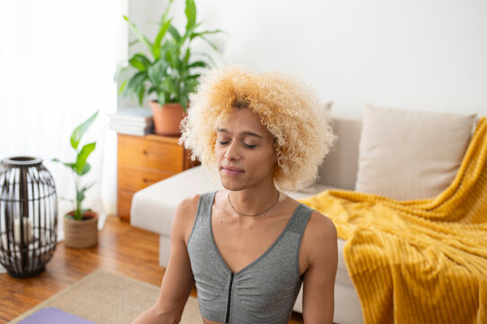 Transgender woman meditating with eyes closed at home