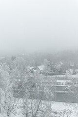 morning fog in winter over houses and trees. winter landscape