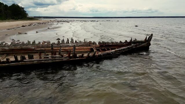 Abandoned shipwreck, An abandoned broken boat full of holes lying on the seashore. Wreck ship on reefs in sea or ocean. The sunken ship, the ship ran aground. Ecological disaster of the Aral Sea.