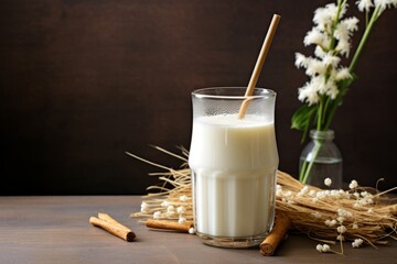 Ice-cold milk in a glass with a fun straw, accompanied by fragrant vanilla pods on a vintage wooden table