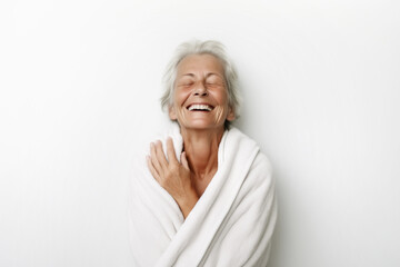 Elderly woman wrapped in a towel, eyes closed, feeling good after spa, bodycare and skincare, on white background - Powered by Adobe