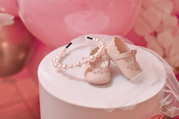 A child's pair of shoes and a hoop for the head. The concept of celebrating the first birthday.