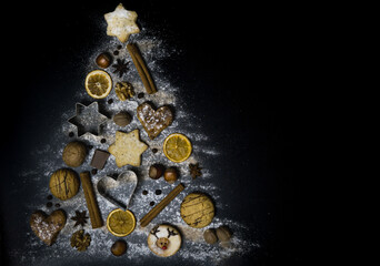 Weihnachtskekse, Gewürze und Ausstechformen tannenbaumförmig arrangiert, schwarzer Hintergrund,...