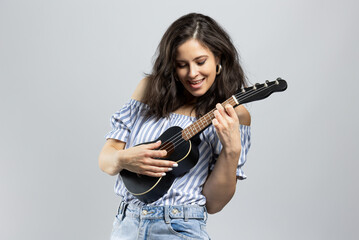 Cute brunette playing ukulele