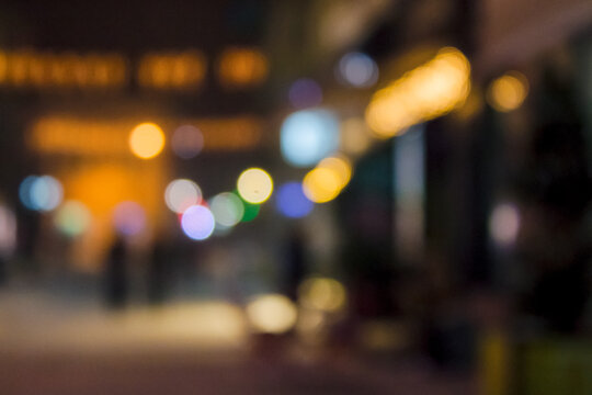 town street at night in winter holiday season. blurred festive urban background with bokeh effect