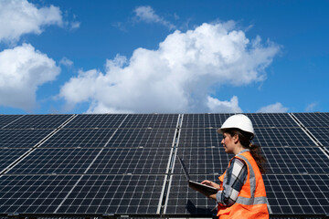 Young engineer inspect installation of solar panels installed check  with blueprint on the field, with recording inspection data on pc.