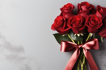 A bouquet of red roses with a satin ribbon bow on a light background. Holiday banner, card