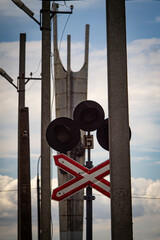 A traffic light at a railway crossing on the background of an obelisk