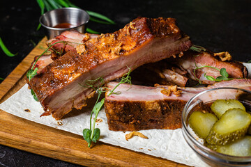 Grilled pork ribs on a wooden board with sauce