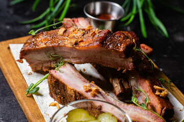Grilled pork ribs on a wooden board with sauce