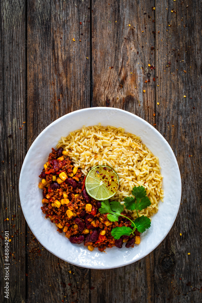 Poster Chili con carne with rice on wooden table - Posters