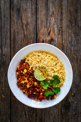Chili con carne with rice on wooden table