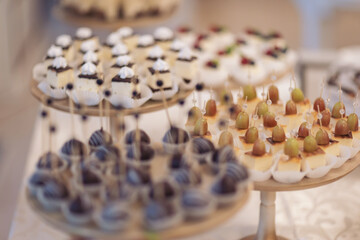 Closeup view photography of many small souffle cakes served on plate on table for cocktail party or on shelves of store. Christmas, birthday or wedding holiday dinner. catering food. tasty dessert.