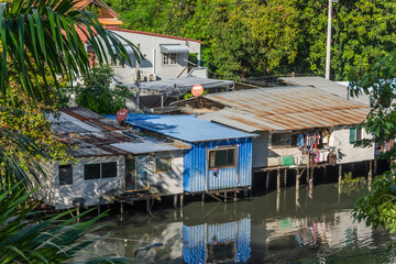 Fototapeta na wymiar Houses barracks on the water along the river canal in Thailand.