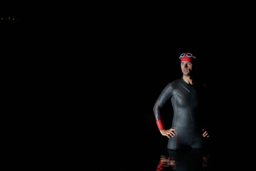 Authentic triathlete swimmer having a break during hard training on night