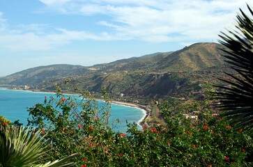 Picturesque panoramic landscape view of Sicily at sunny day. Turquoise colored sea and mountains against blue sky. Santo Stefano di Camastra. Travel and tourism concept. Sicily, Italy