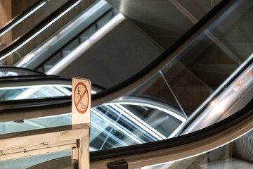 Escalators with safety notices of the dangers of inappropriate use. - obrazy, fototapety, plakaty