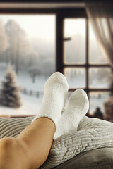 Woman legs with warm winter socks. Free space for your decoration. Window background in home...