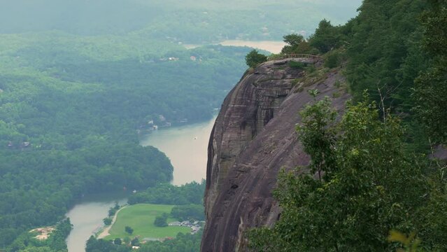 Chimney Rock state park in North Carolina. Exclamation Point trekking overlook with steep cliff and Lake Lure in distance. USA travel destination