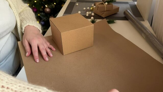 a woman packs a gift box in crab wrapping paper