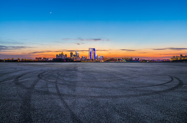 Asphalt road square and city skyline with modern buildings at night in Suzhou, Jiangsu Province, China. Road platform and city skyline background.