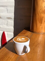 Hot cappuccino in a mug placed on a wooden table