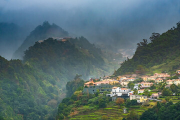 Traditional terrace village Sao Vicente, Madeira Island, Portugal. Small houses and gardens among a...