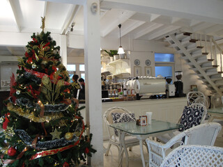 Chiang Mai, Thailand - Friday, December 01, 2023 : christmas tree in a restaurant, a unified white tone table chairs, Old City