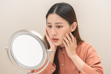 Dermatology, expression face worry asian young woman looking mirror hand touch face at dark spot of...